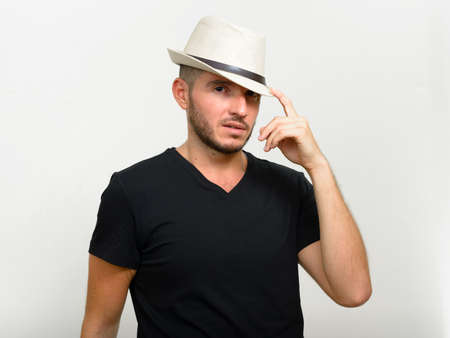 Studio shot of handsome bearded Hispanic man wearing hatの写真素材