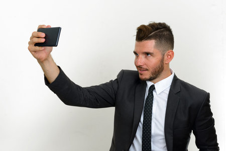 Portrait of handsome bearded Hispanic businessman in suit