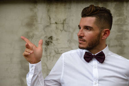 Handsome bearded Hispanic businessman wearing bow tie outdoorsの写真素材