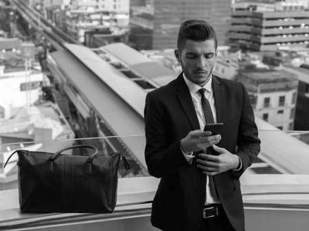 Handsome bearded Hispanic businessman against view of the cityの写真素材
