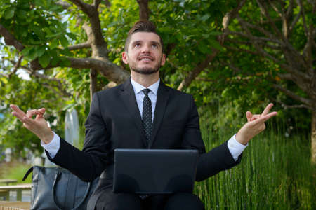 Handsome bearded Hispanic businessman with nature in the city outdoorsの写真素材