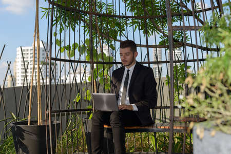 Handsome bearded Hispanic businessman with nature in the city outdoorsの写真素材