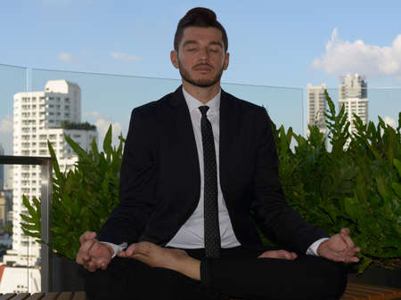 Handsome bearded Hispanic businessman with nature in the city outdoorsの写真素材