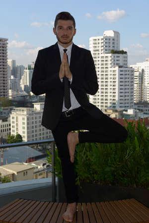 Handsome bearded Hispanic businessman with nature in the city outdoorsの写真素材