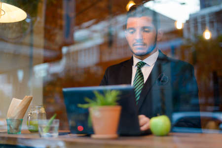 Handsome bearded Hispanic businessman at the coffee shopの写真素材