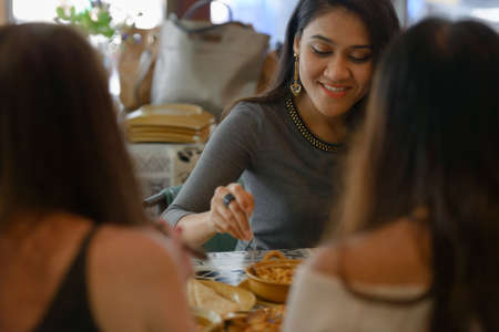 Three young beautiful women as friends together at the coffee shopの写真素材