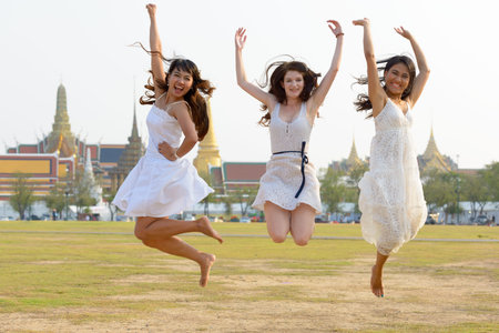 Three multi ethnic young beautiful women as friends together in the park