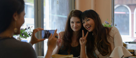 Three young beautiful women as friends together at the coffee shop