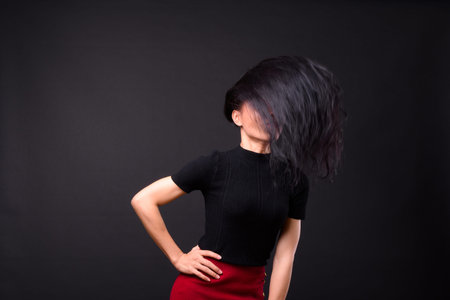 Young beautiful Asian transgender businesswoman against black background