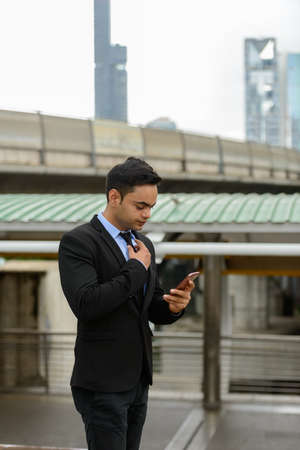 Young handsome Indian businessman in the cityの写真素材