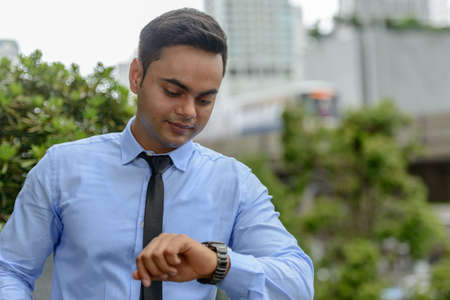 Young handsome Indian businessman in the cityの写真素材