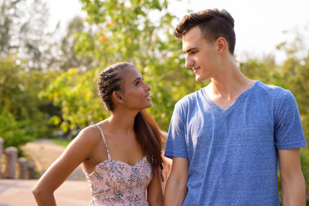 Portrait of young multi ethnic couple relaxing together at the park