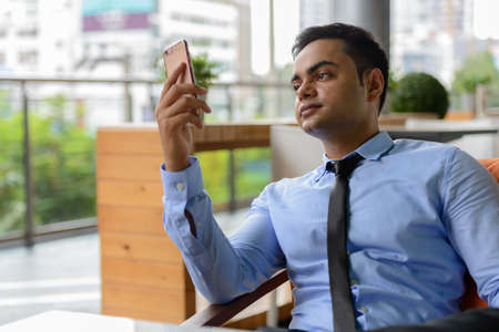 Young handsome Indian businessman in the cityの写真素材