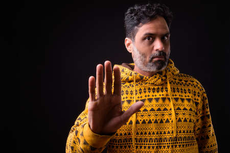 Portrait of mature bearded Indian man with curly hair wearing hoodieの写真素材
