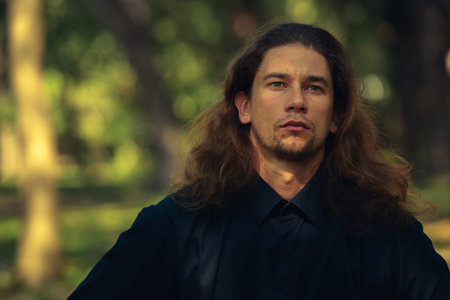 Handsome bearded businessman with long hair at the park
