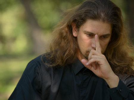 Handsome bearded businessman with long hair at the park