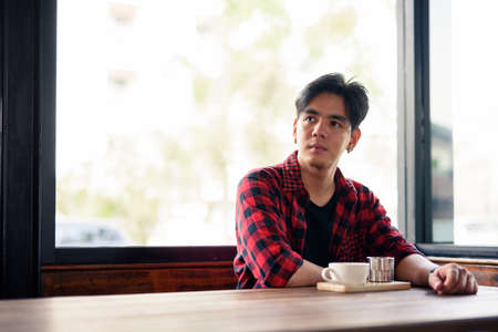 Young handsome Asian hipster man at the coffee shopの写真素材