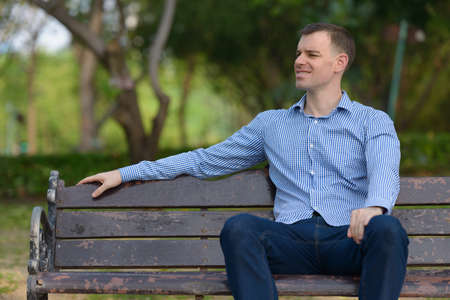 Portrait of happy businessman relaxing at the parkの写真素材