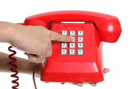 Portrait of hand holding and dialing old telephoneの写真素材