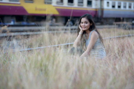 Happy young beautiful Asian woman at the railway station
