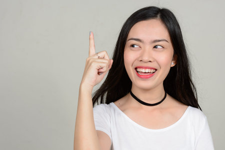 Portrait of happy young beautiful Asian woman