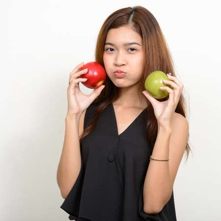 Portrait of young beautiful Asian woman against white backgroundの写真素材