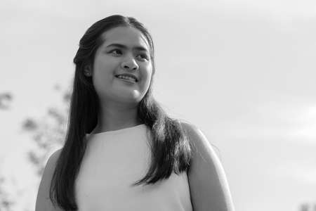 Young beautiful Asian woman at the park outdoors in black and whiteの写真素材
