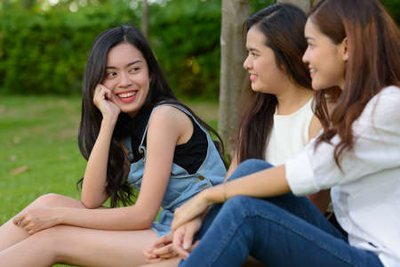 Three young Asian women as friends together at the parkの写真素材