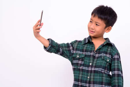 Portrait of cute Asian boy taking selfie with phoneの写真素材
