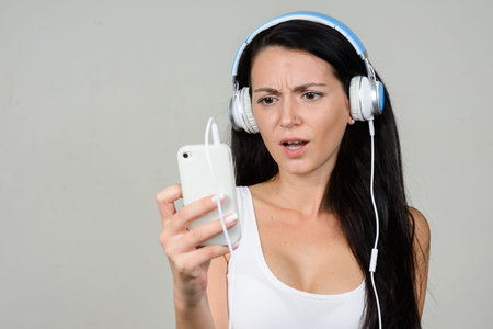 Portrait of beautiful woman using phone and listening to music