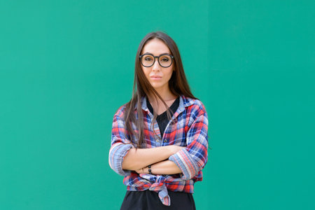 Portrait of young beautiful hipster woman with eyeglasses against blue background
