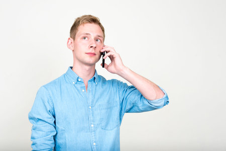 Portrait of young handsome blond businessman talking on the phone