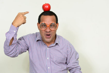 Portrait of happy overweight Indian businessman with appleの写真素材