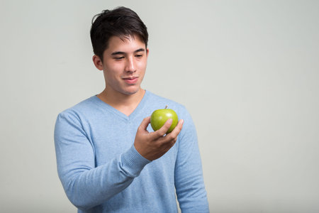 Portrait of young handsome man with apple