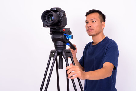 Portrait of young Asian man with camera