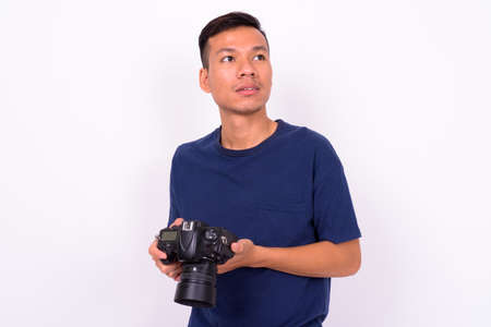 Portrait of young Asian man with cameraの写真素材