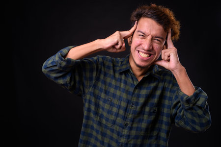 Portrait of young Asian hipster man with curly hair