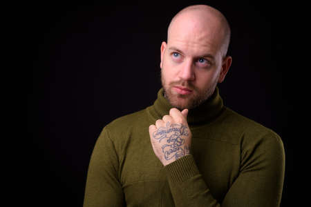 Handsome bald bearded man against black backgroundの写真素材