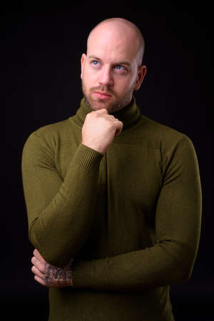 Handsome bald bearded man against black backgroundの写真素材