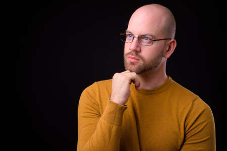 Handsome bald bearded man against black backgroundの写真素材