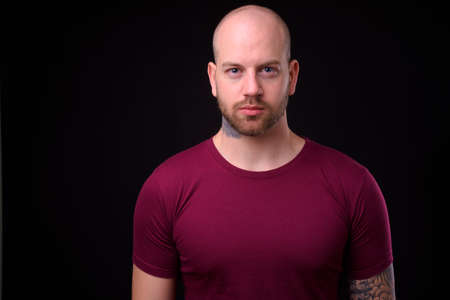 Handsome bald bearded man against black backgroundの写真素材