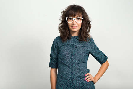 Portrait of beautiful businesswoman with eyeglasses against white backgroundの写真素材