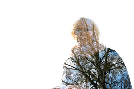 Double exposure of senior woman and branches of tall deciduous treeの写真素材