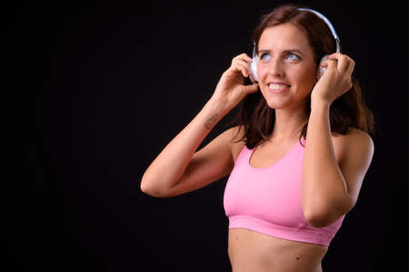 Portrait of happy young beautiful woman listening to music and ready for gymの写真素材