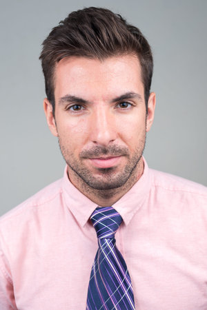 Portrait of young handsome Hispanic businessman against white backgroundの写真素材