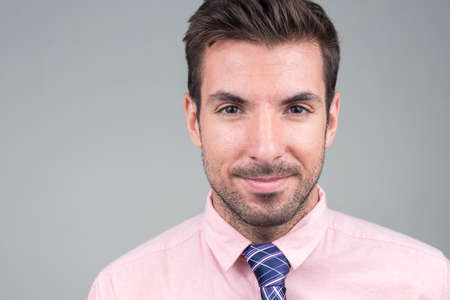 Portrait of young handsome Hispanic businessman against white backgroundの写真素材