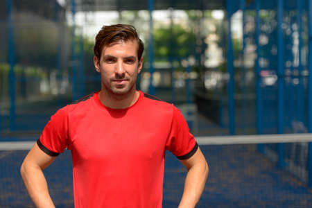 Young handsome Hispanic man at the padel courtの写真素材