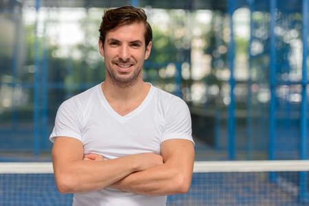 Happy young handsome Hispanic man at the padel courtの写真素材