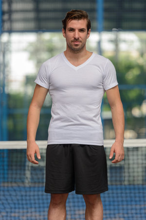 Young handsome Hispanic man at the padel courtの写真素材