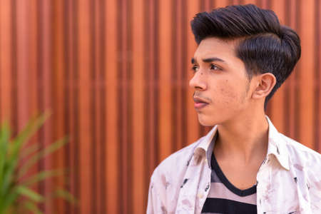 Young handsome Indian teenage boy in the streets outdoorsの写真素材